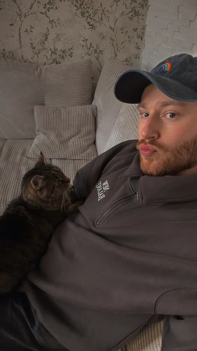 Christopher with a cat on the sofa